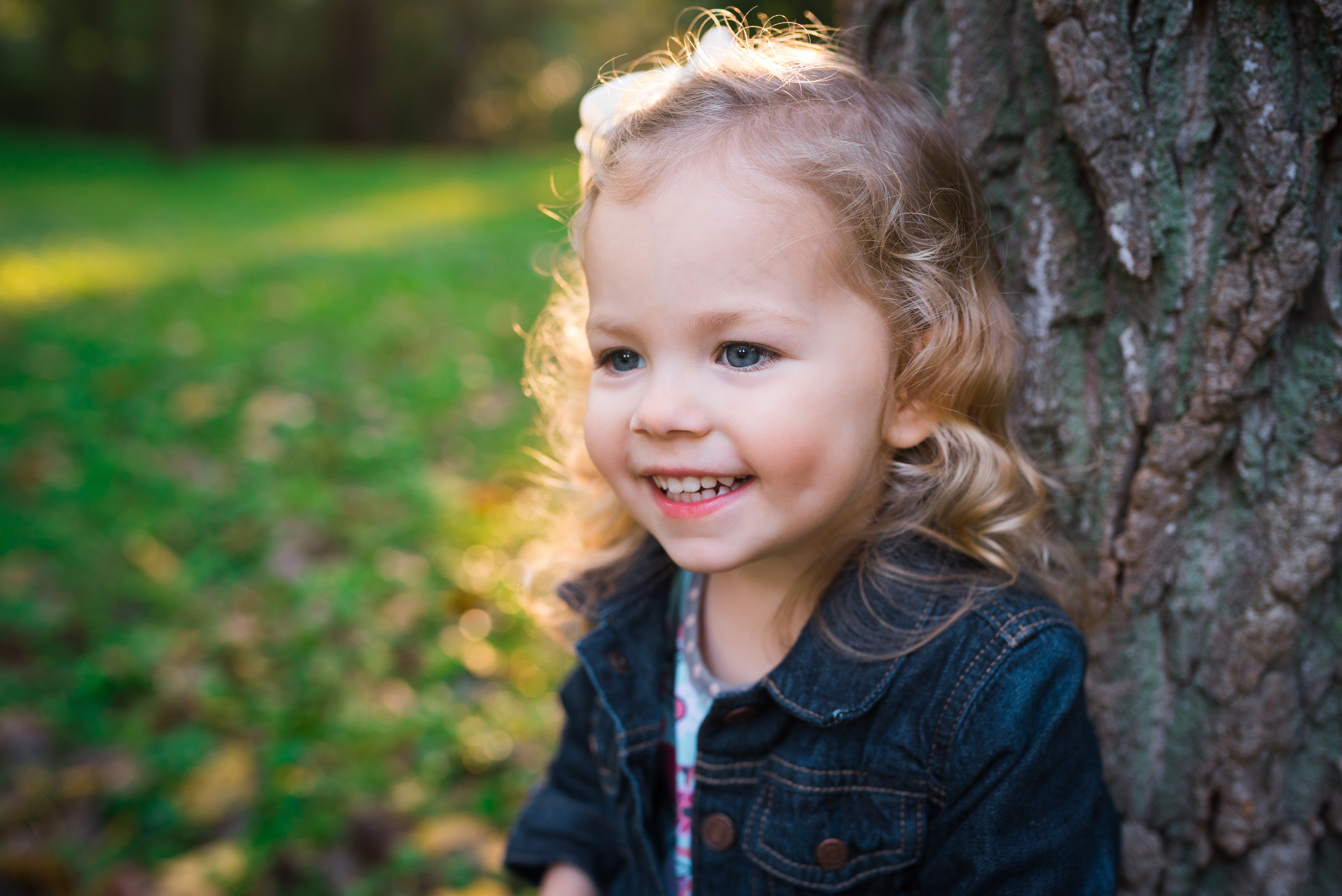 looking girl in denim jacket smiling while looking to the side