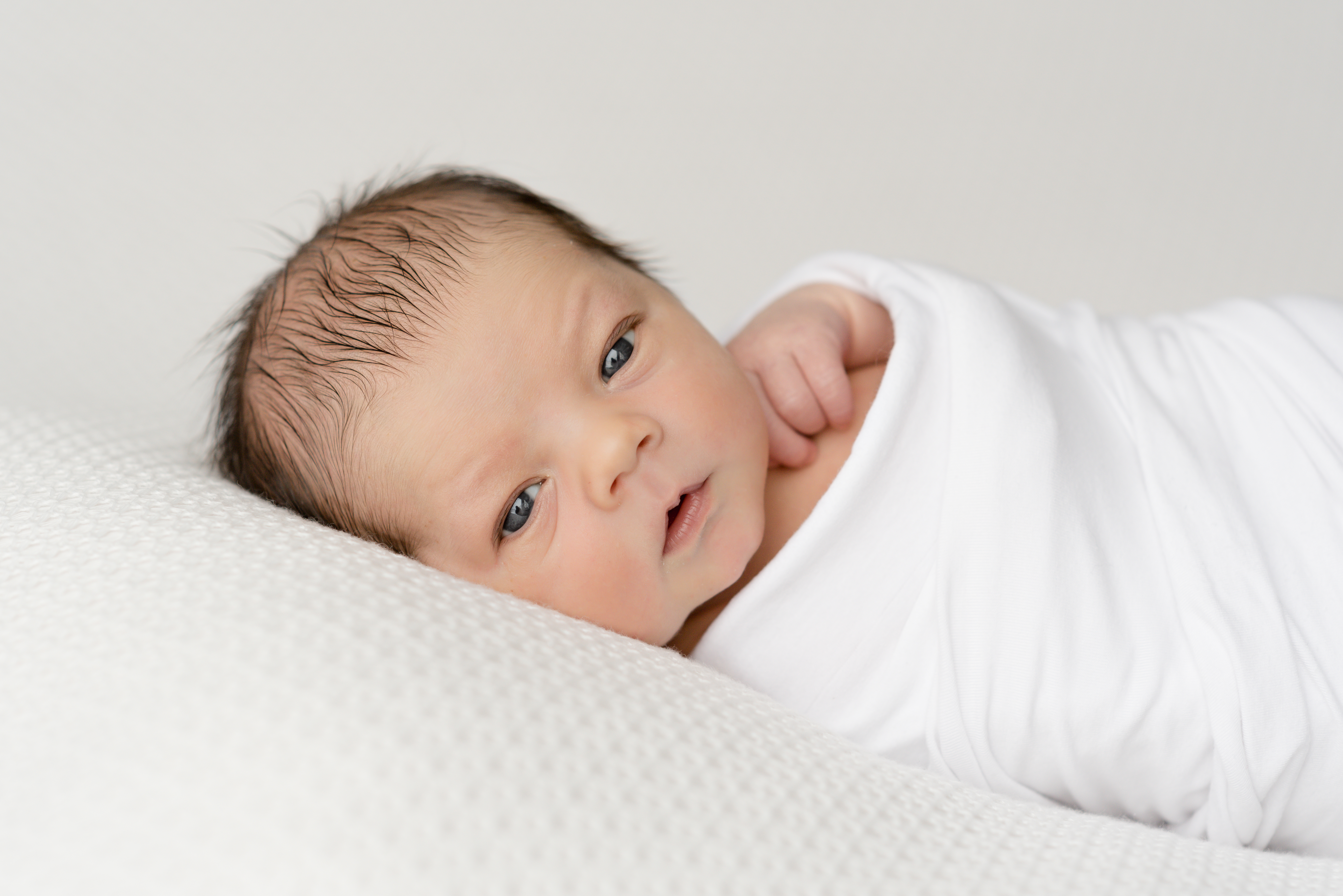 In home newborn photography baby boy wrapped in white
